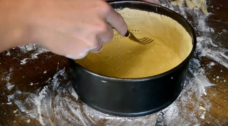 Avec une fourchette, nous piquons le fond et les côtés de la base pour obtenir le gâteau au fromage.