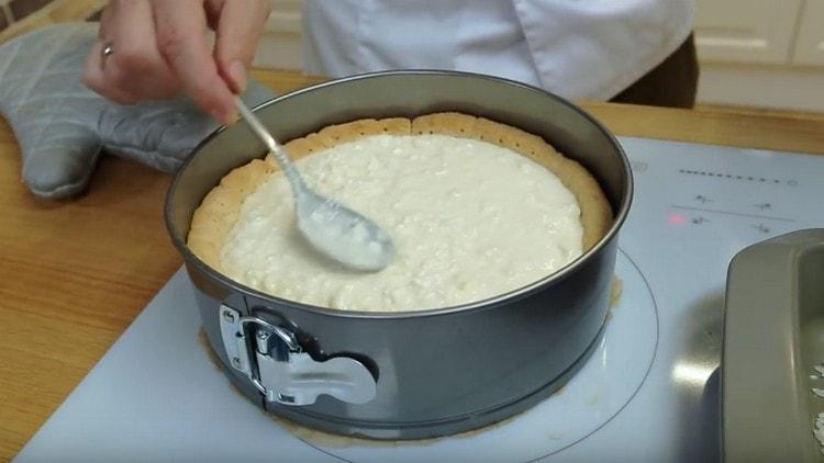 Pour the curd mass on the base, level it.