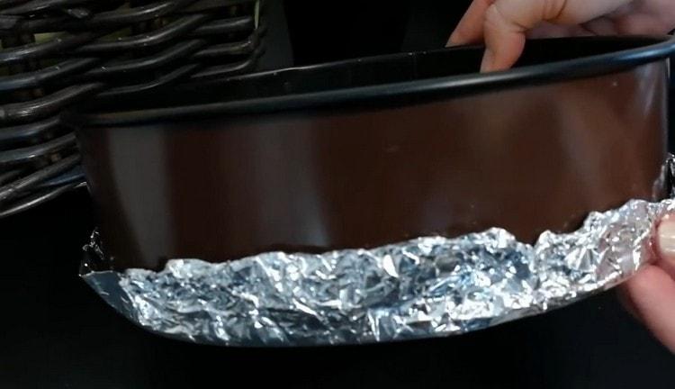 We take out the form with the base for the cheesecake and wrap it with foil.