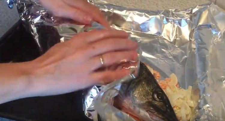 Transfiera el pescado a una almohadilla vegetal y envuélvala cuidadosamente con papel de aluminio.