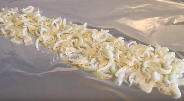 Part of the onion is spread on a large sheet of foil, forming a pillow for the pike.