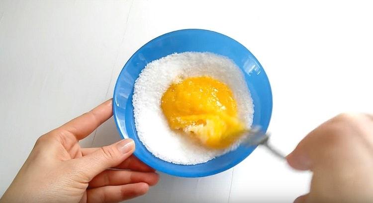 While the milk is boiling, grind the yolks with sugar.