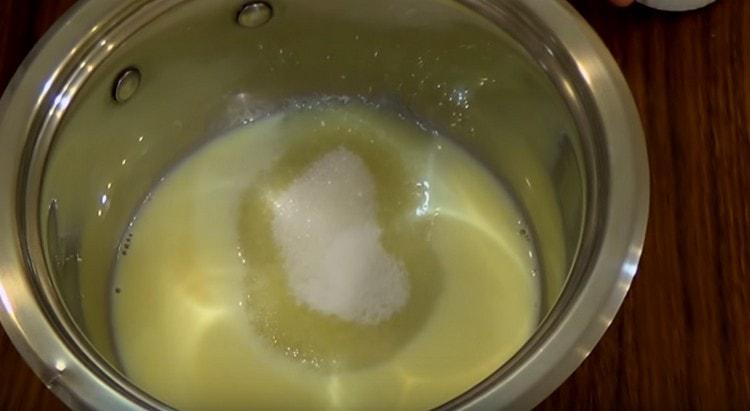 Ajoutez le sucre et le sucre vanillé au mélange de lait et de jaune.