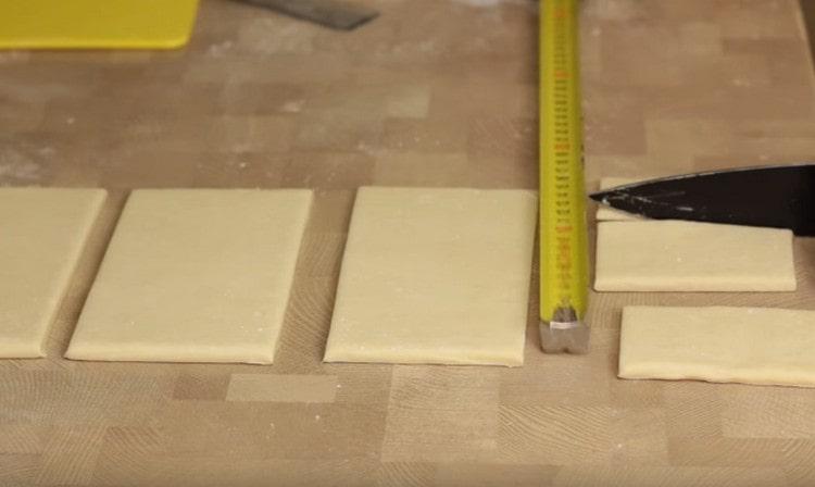 The dough layer is cut into small rectangles.