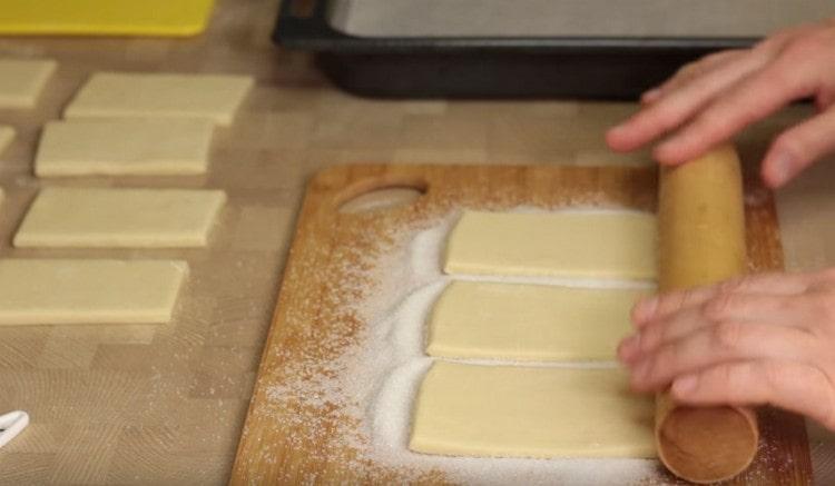 With a rolling pin, we press the dough into sugar a little.