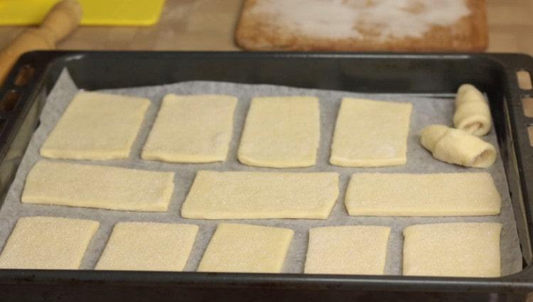 El azúcar se extiende la pieza de trabajo en una bandeja para hornear, que debe cubrirse con pergamino.