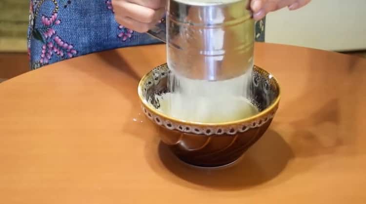 Tamizar la harina para hacer bollos con mermelada