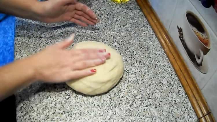 Knead the dough to make raisin rolls.