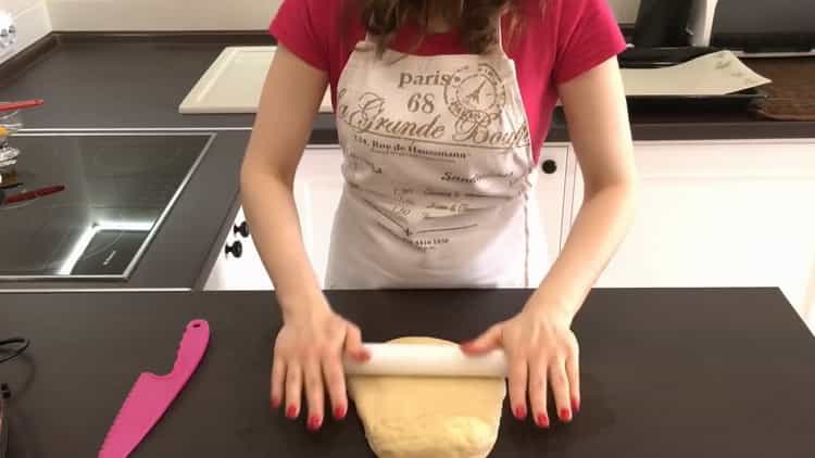 Abaisser la pâte pour faire des pains à la levure avec des graines de pavot