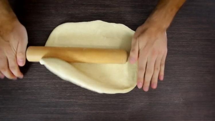 Rouler la pâte pour faire des petits pains aux graines de pavot