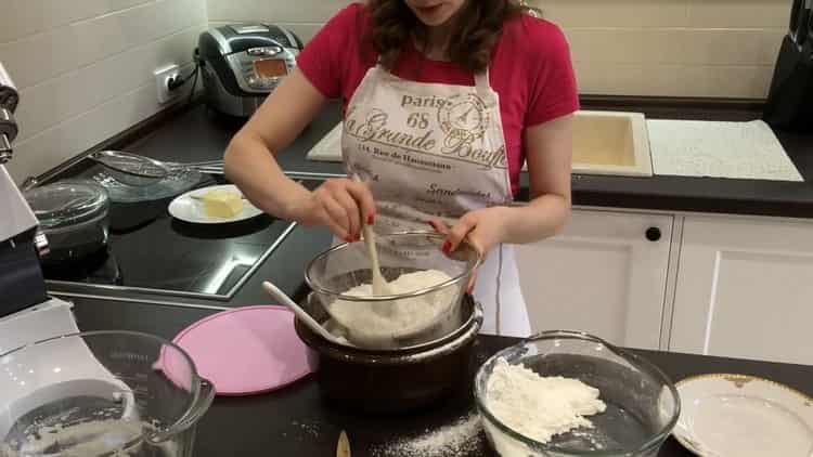 Sift flour to make yeast buns with poppy seeds