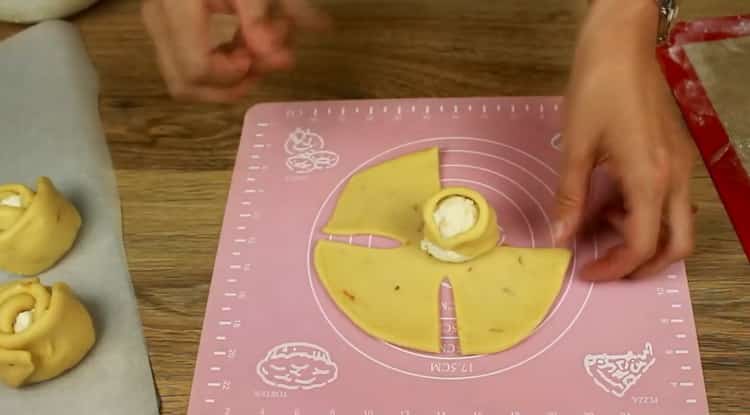 Para hacer bollos con requesón a partir de masa de levadura, coloque el relleno en el medio