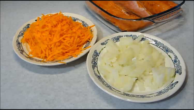 Cortar cebollas y zanahorias para hacer salmón rosado