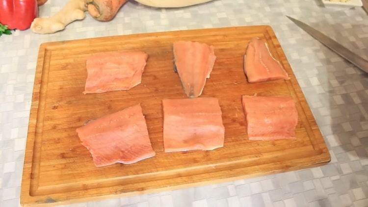 Da biste kuhali ružičasti losos s povrćem u pećnici, izrežite ribu