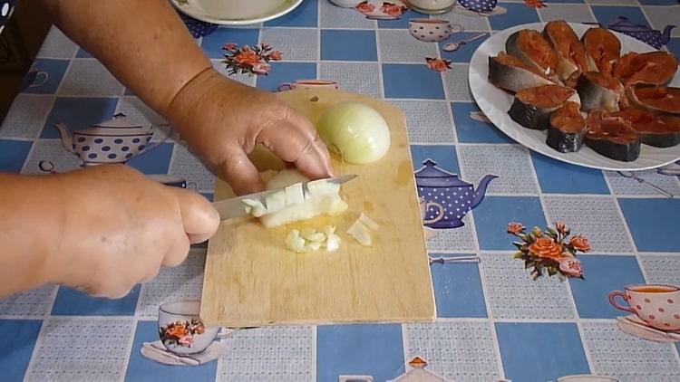 Para cocinar el guiso de salmón rosado, pica la cebolla