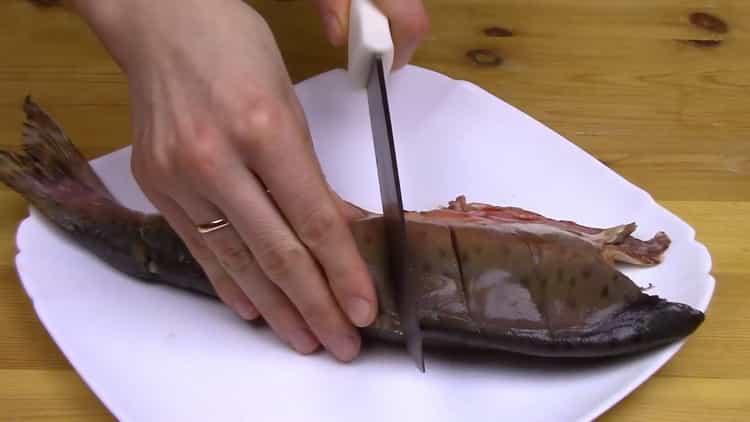 Para cocinar salmón rosado entero en el horno, haga incisiones en el pescado.