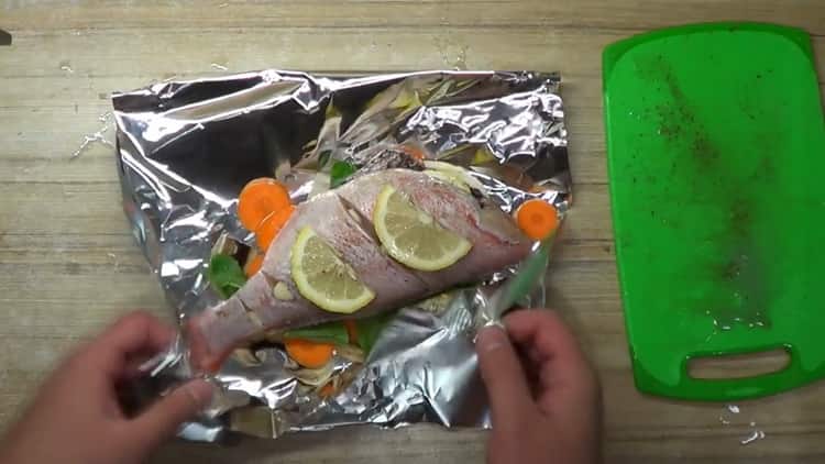 pour cuire la perche au four en papier d'aluminium, mettez le poisson citronné sur le papier d'aluminium