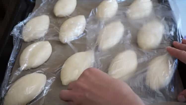 Upang makagawa ng mga pie na may mga sibuyas at itlog, ilagay ang kuwarta sa isang baking sheet