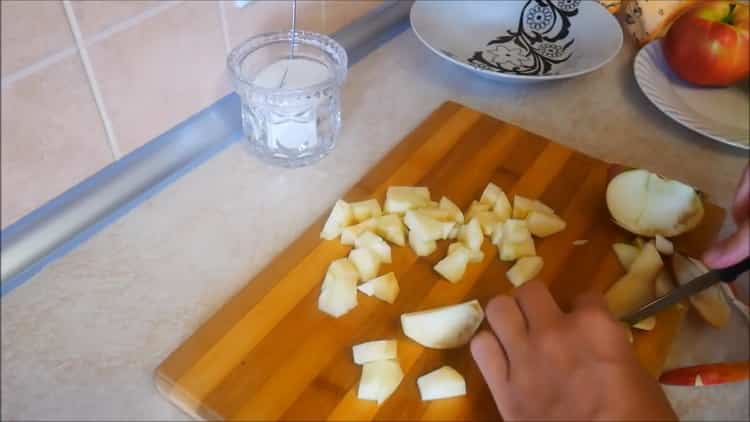 Para hacer pasteles de manzana en el horno, corte las manzanas.