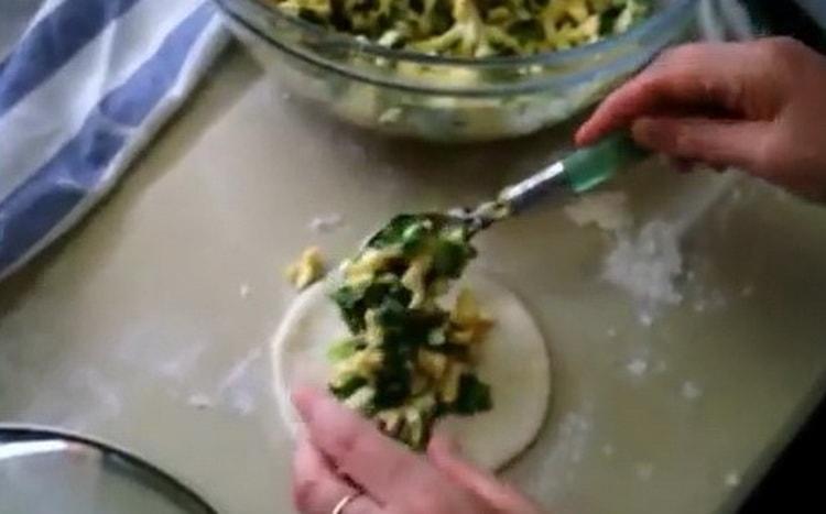 Para hacer pasteles con huevos y cebollas verdes, ponga el relleno sobre la masa