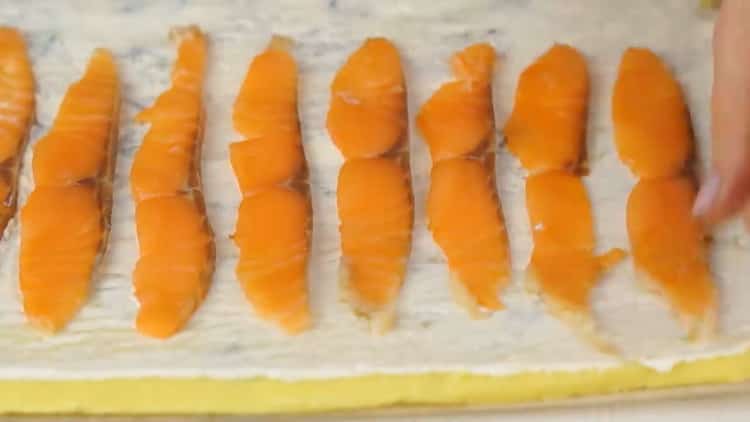 Pour préparer un rouleau avec du poisson rouge, mettez le poisson haché sur la pâte