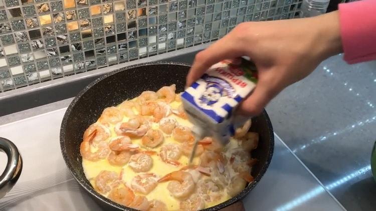 Pour faire des spaghettis aux crevettes dans une sauce crémeuse, ajoutez de la crème