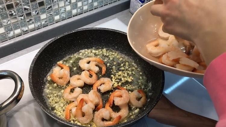 To make shrimp spaghetti in a creamy sauce, fry the shrimp