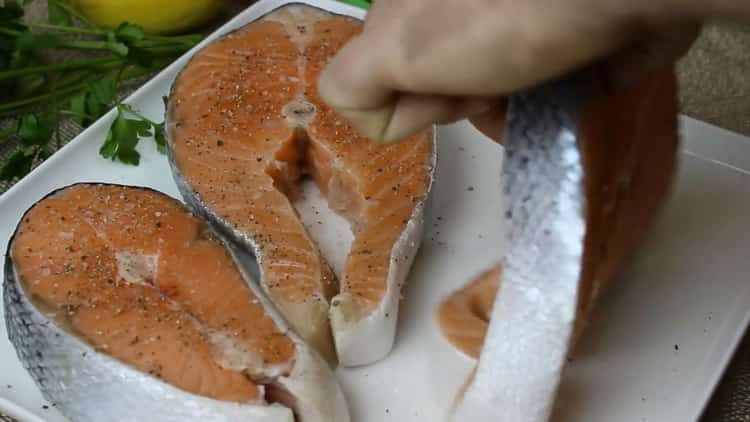 Cuire un steak de saumon dans une poêle, poivrer et saler le poisson