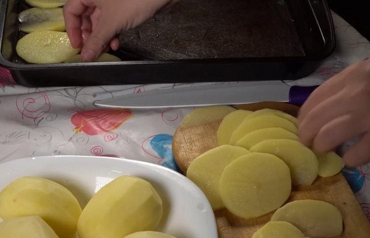 Pour préparer la morue avec des pommes de terre au four, préparez une plaque à pâtisserie
