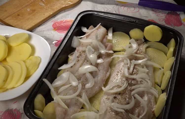 Da biste pripremili bakalar s krumpirom u pećnicu, stavite luk na ribu