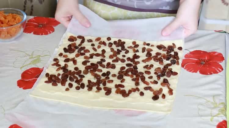To make puff pastry snails, put raisins on the dough
