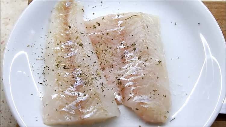 Para cocinar el filete de lucioperca en el horno, espolvorea el pescado con especias.