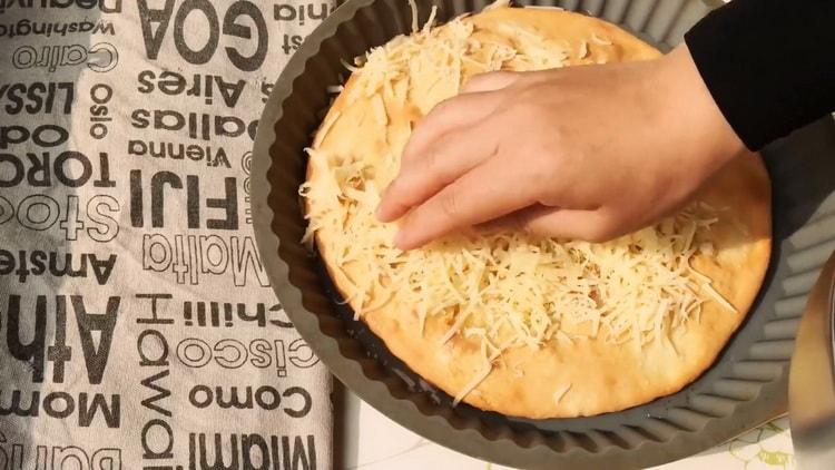 Upang ihanda ang khachapuri, ilagay ang gadgad na keso sa isang baking sheet