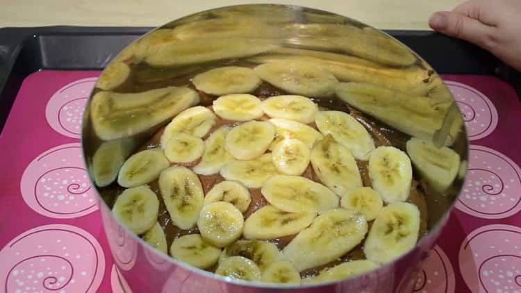 Para hacer un pastel de chocolate y plátano, pon el plátano sobre la masa