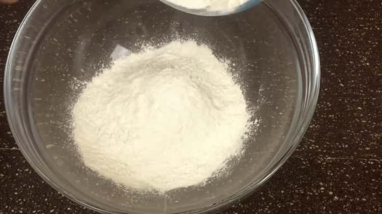 Tamizar la harina para hacer un muffin de chocolate con cereza