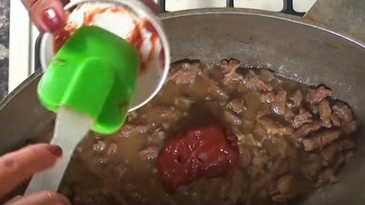 Ajoutez à la viande avec des oignons une cuillerée de farine et de pâte de tomate.