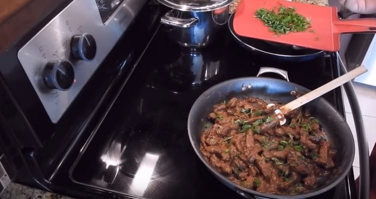 Ready beef stroganoff from beef liver with sour cream can be sprinkled with chopped herbs.