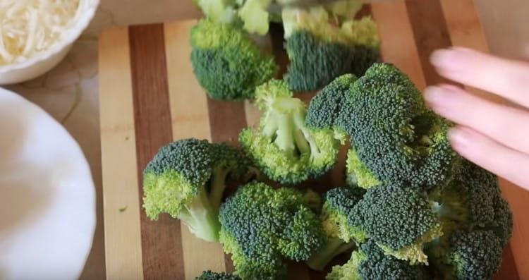 Nous divisons le chou-brocoli avec un couteau en inflorescences.