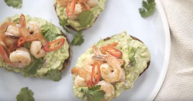 Such a bruschetta with avocado and shrimp would be appropriate even on the festive table.