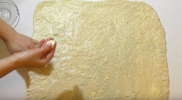 Lubrifiez la couche de pâte obtenue avec du beurre.