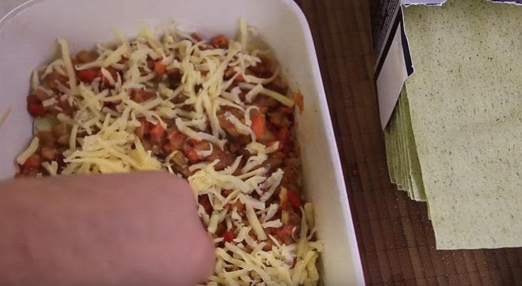 Saupoudrer la couche de légumes avec du fromage râpé.