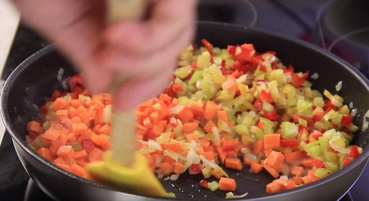 Agregue zanahorias y pimienta a la cebolla.