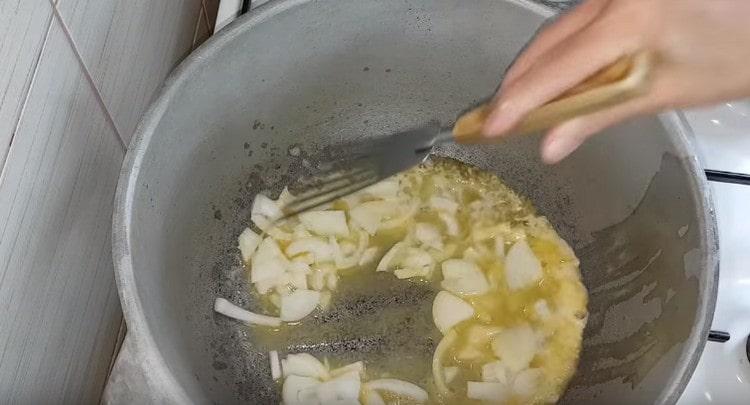 En aceite, freír la cebolla en rodajas a medias.