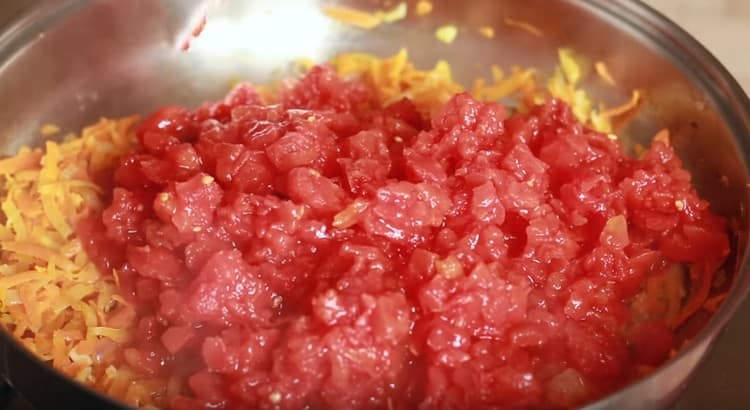 Ajouter les tomates en conserve hachées à la moitié de la masse de légumes.