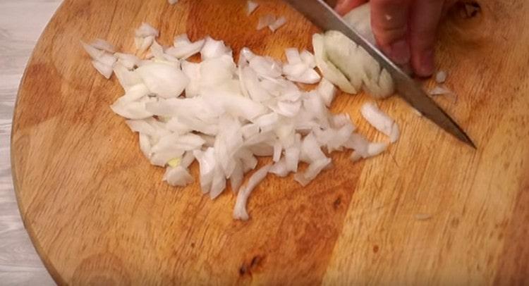 Para preparar la salsa, picar la cebolla.