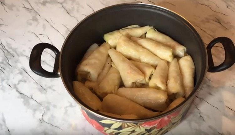 Formed cabbage rolls stack tightly in a pan.