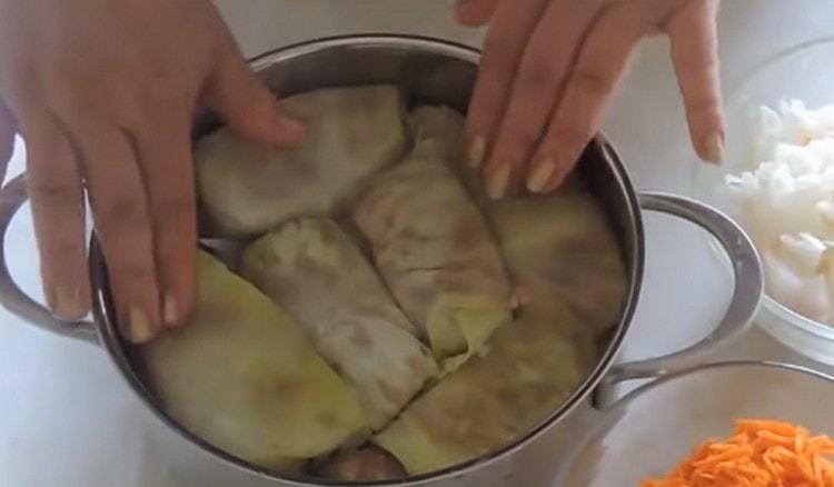 Des rouleaux de chou moulé sont disposés dans une casserole.