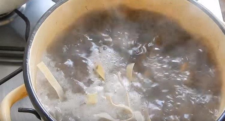 Ajouter les nouilles à la poêle avec les champignons et les pommes de terre, puis les faire frire.