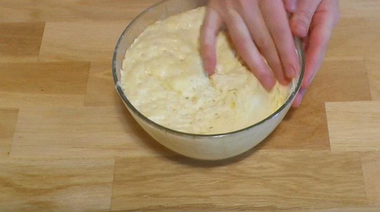 Avec les mains graissées, nous écrasons la pâte levée.