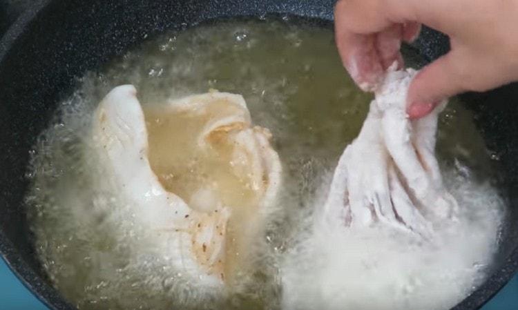 Bread squid in flour with spices and spread it in a frying pan.